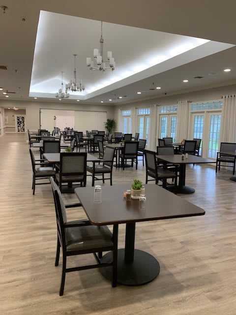 A spacious and modern dining room with neatly arranged tables and chairs.
