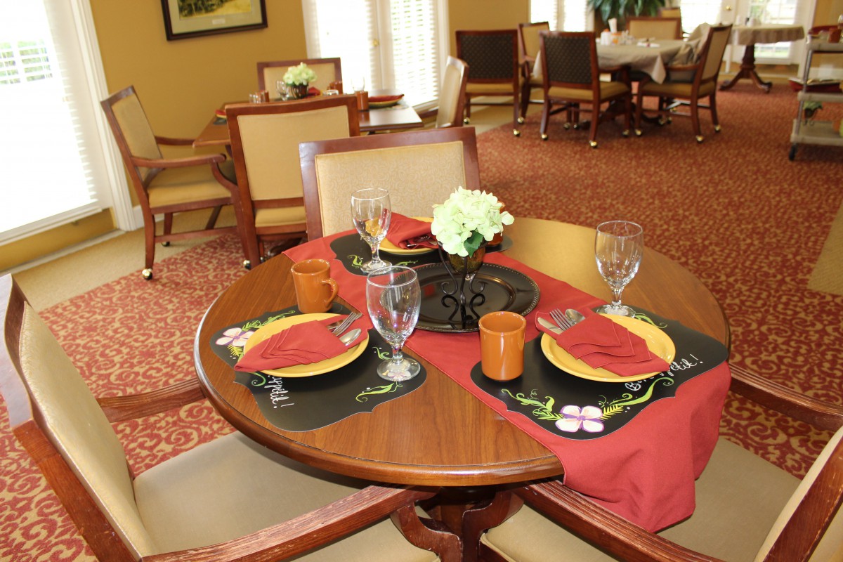 Elegant dining table set with red and black themed decor in a formal restaurant setting.