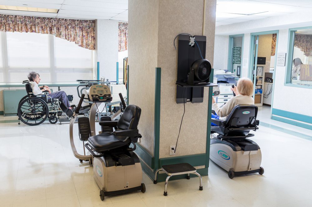 A rehabilitation facility with exercise equipment and a person using a machine.