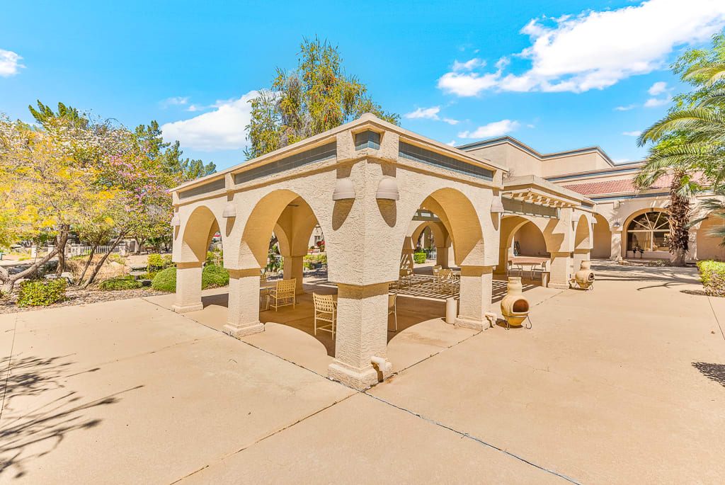 An outdoor structure with arches under a clear blue sky.