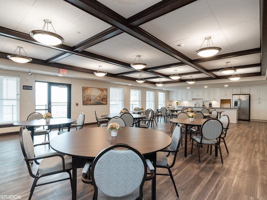 A spacious dining room with modern decor and multiple tables and chairs.