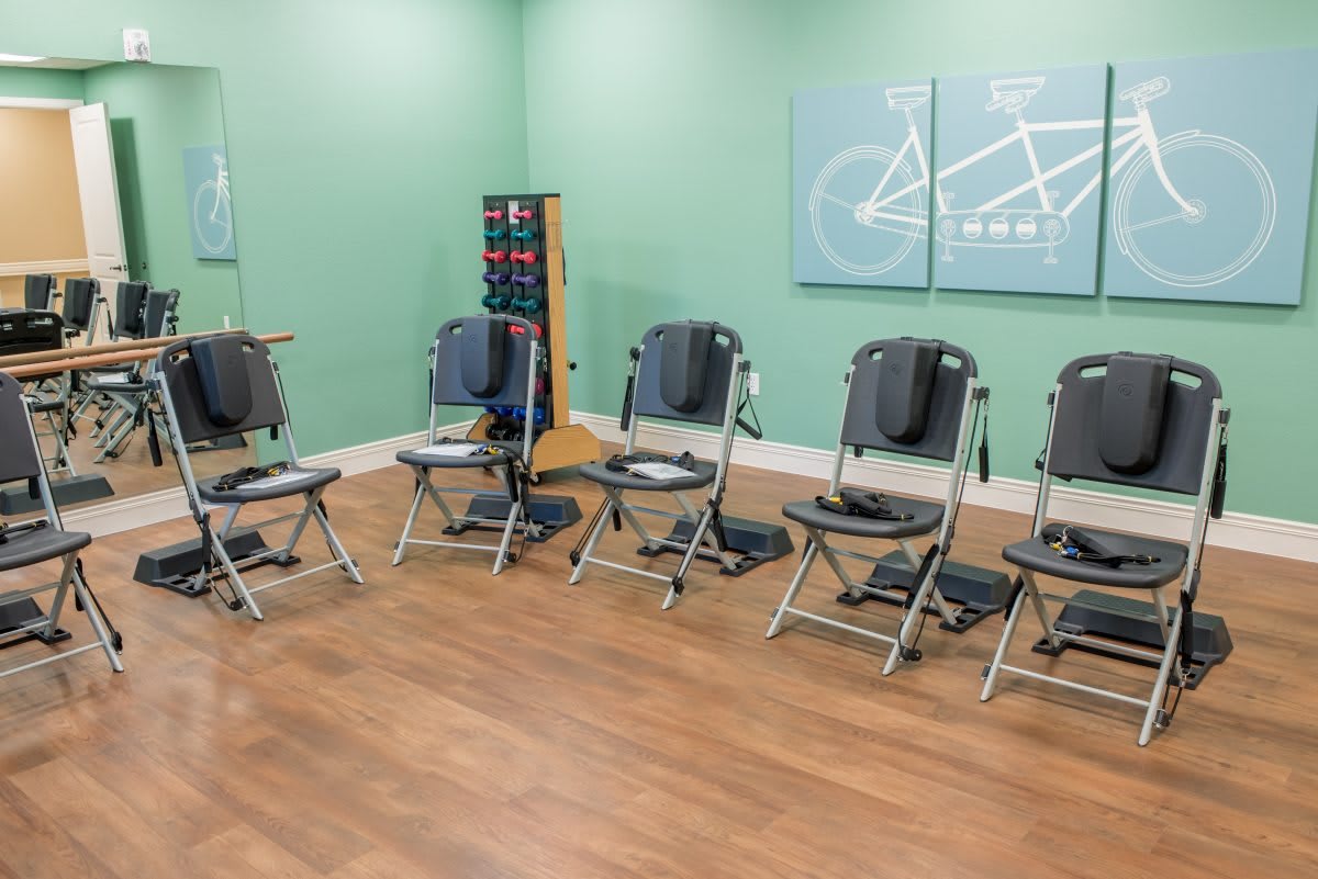 A small exercise area with folding chairs, weights, and a minimalist setup.