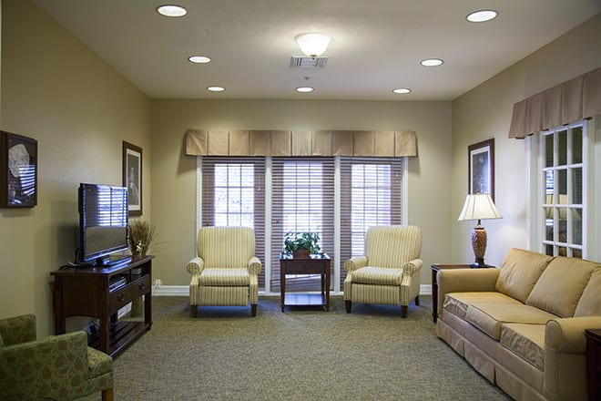 A cozy living room with comfortable seating, a television, and soft lighting.