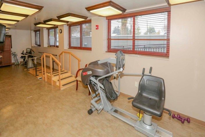 A rehabilitation gym featuring exercise equipment and a set of stairs.