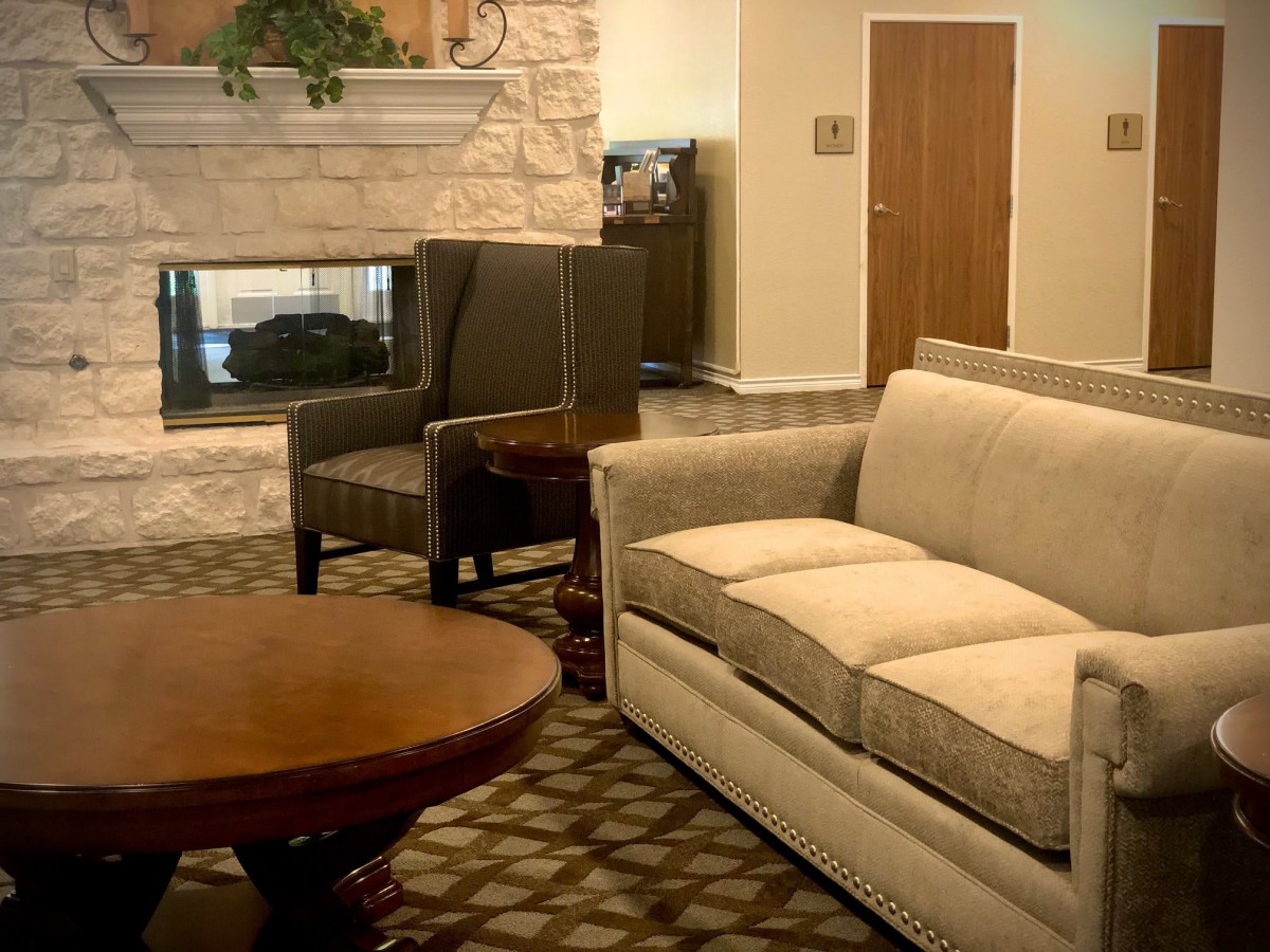 A cozy living room featuring a comfortable sofa, armchair, coffee table, and a fireplace.