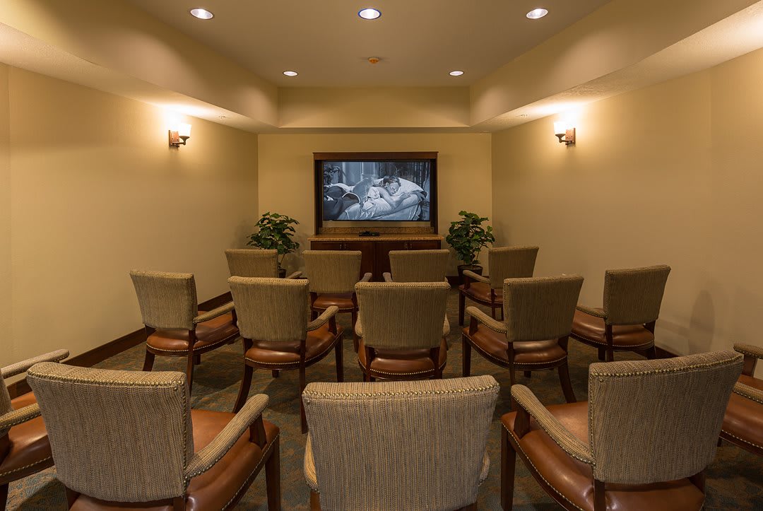 A cozy home theater setup with multiple chairs facing a large screen.