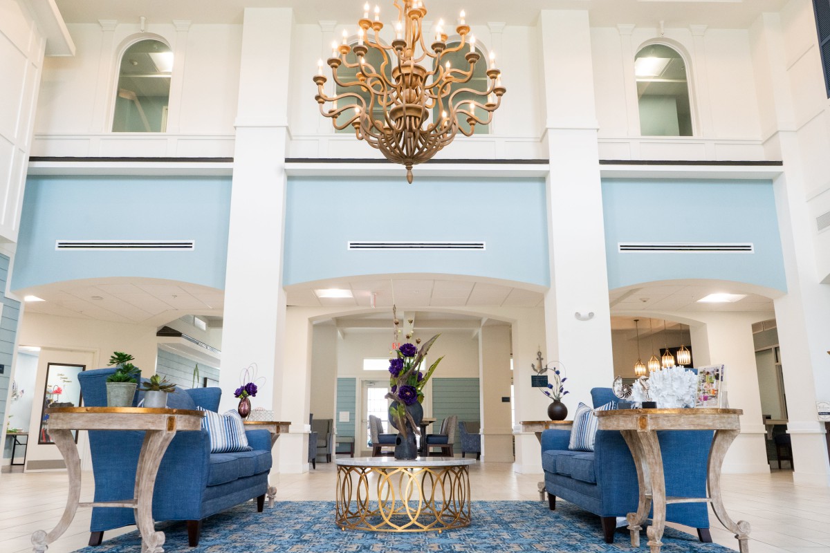 A luxurious lobby with elegant blue furniture and a grand chandelier.