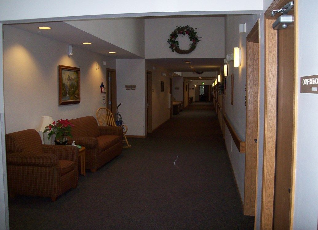 A decorated hallway with seating and wall art.