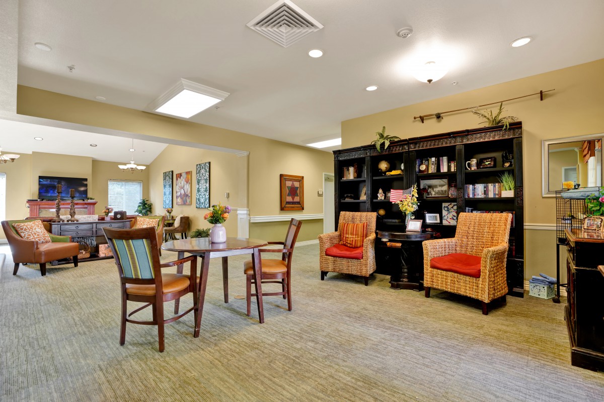 A cozy living room with seating area and bookshelf.