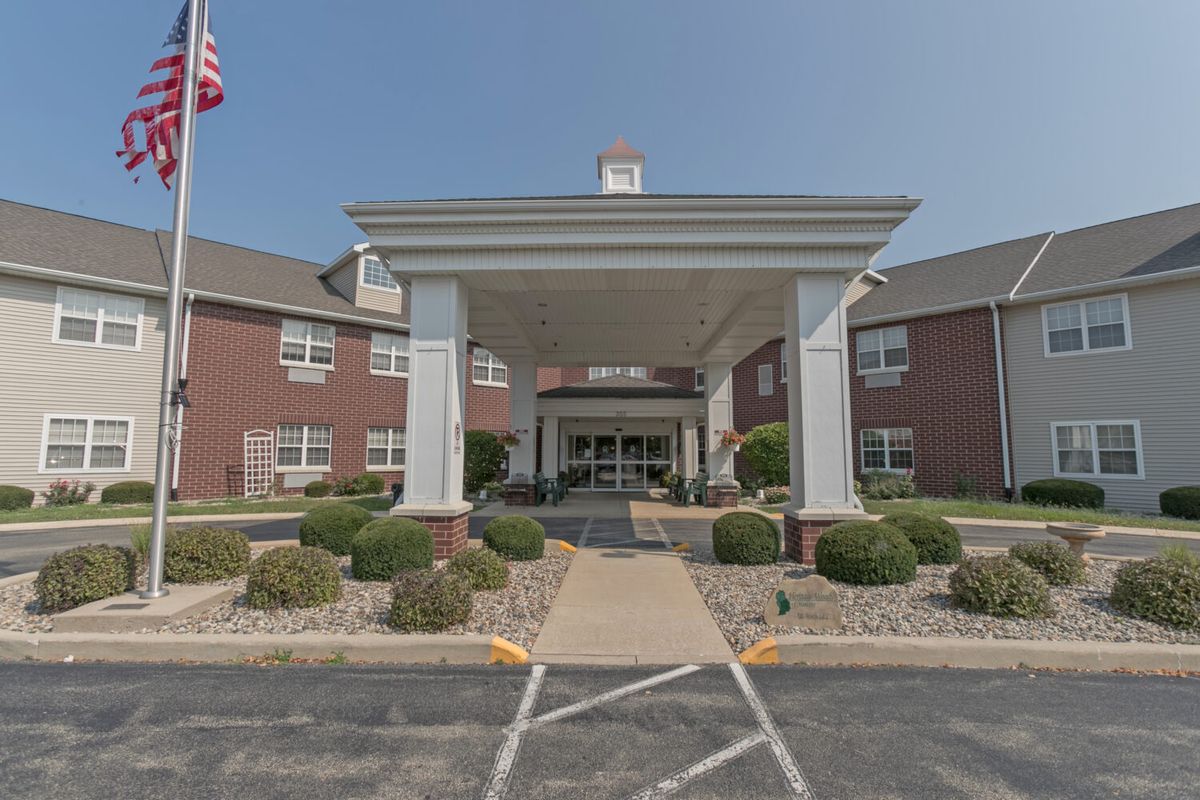 A building entrance with a covered driveway and landscaped pathway.