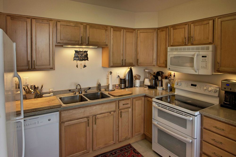 A cozy kitchen with wooden cabinets and modern appliances.
