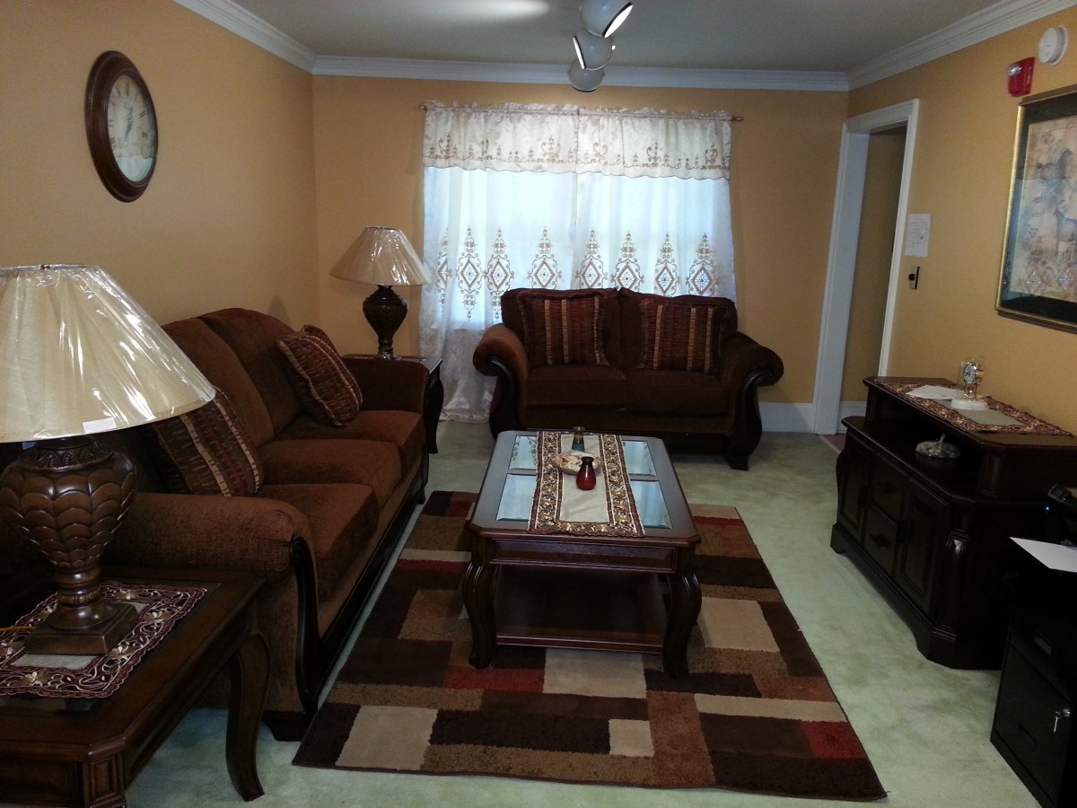 A cozy living room with a brown sofa set, coffee table, and decorative rug.