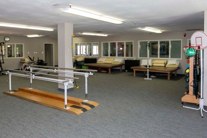 A rehabilitation clinic featuring parallel bars and exercise equipment.
