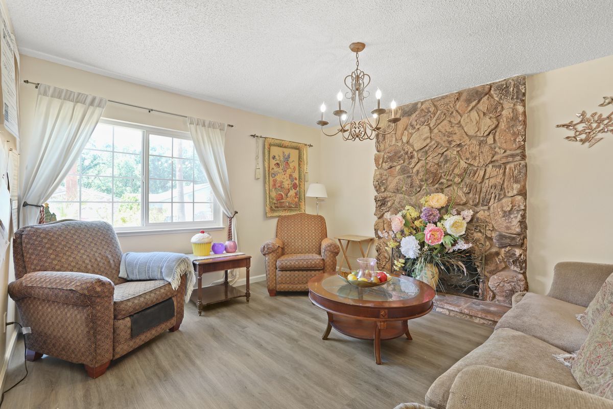 A cozy living room with comfortable furniture, a chandelier, and decorative elements.