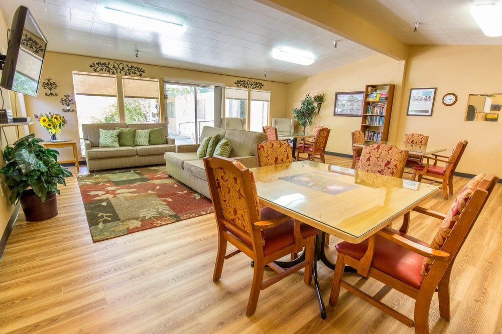 A cozy living and dining area with a sofa, chairs, and table set on wood flooring.