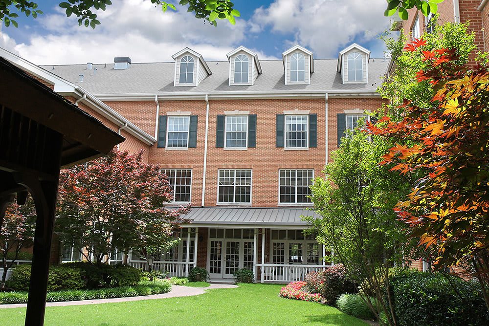 A beautiful brick building with a well-maintained garden and lush greenery.