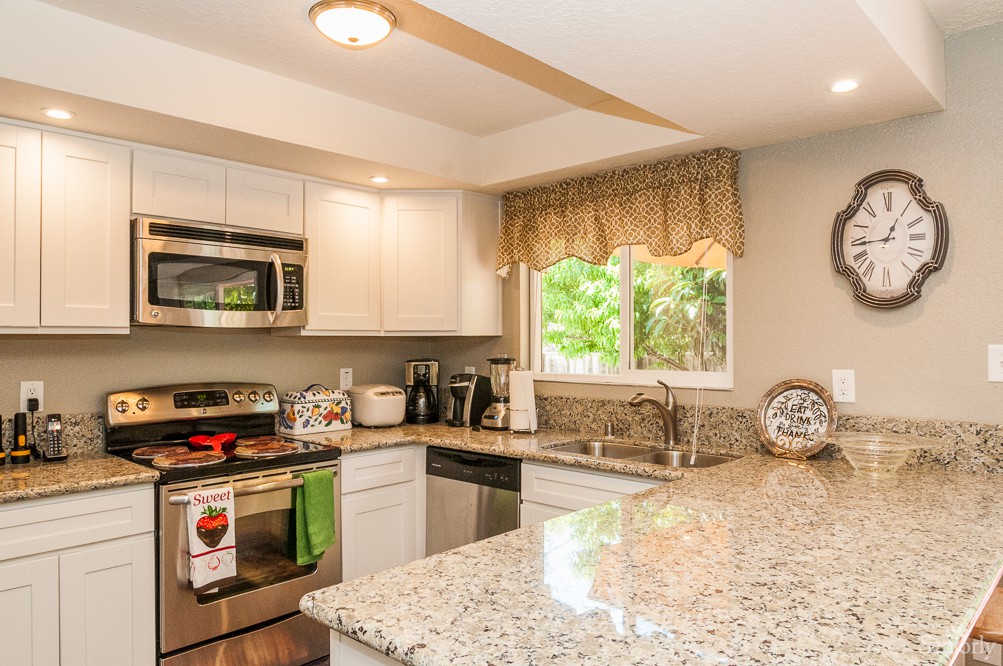 A modern kitchen featuring granite countertops and stainless steel appliances.