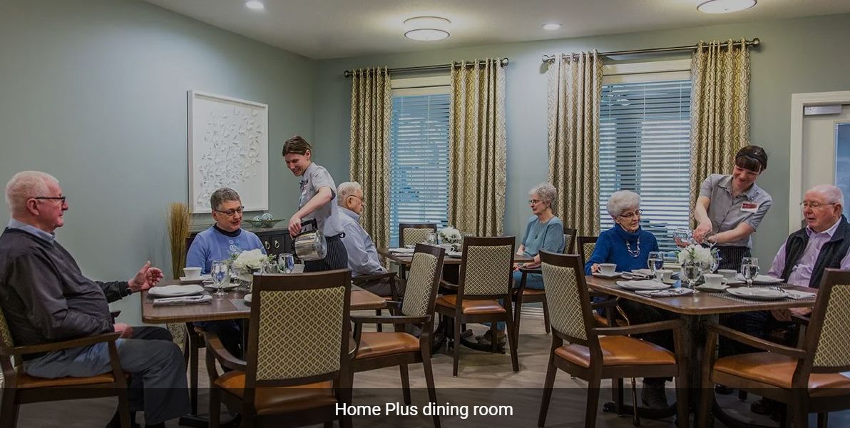 Seniors enjoying a meal in a care facility dining room.