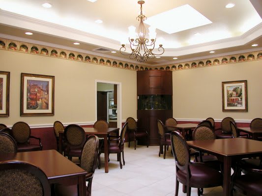 An elegant dining room with classic decor and a central chandelier.