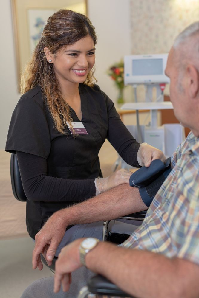 A nurse checks the blood pressure of a patient in a clinical setting.