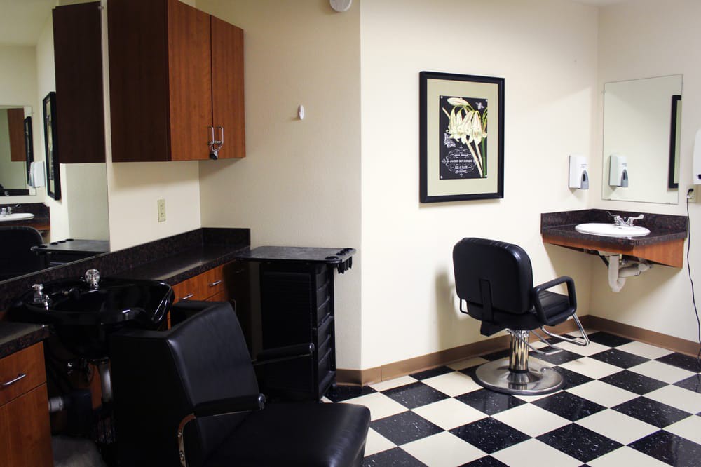 A clean and organized barber shop interior with chairs and a checkerboard floor.