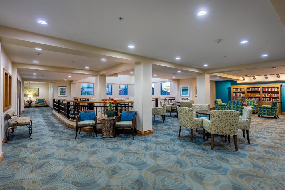 A spacious and well-lit interior seating area with modern furnishings and decorative art on the walls.