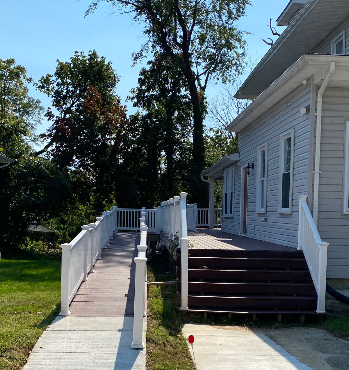 A ramp and stairs leading to the side entrance of a house.