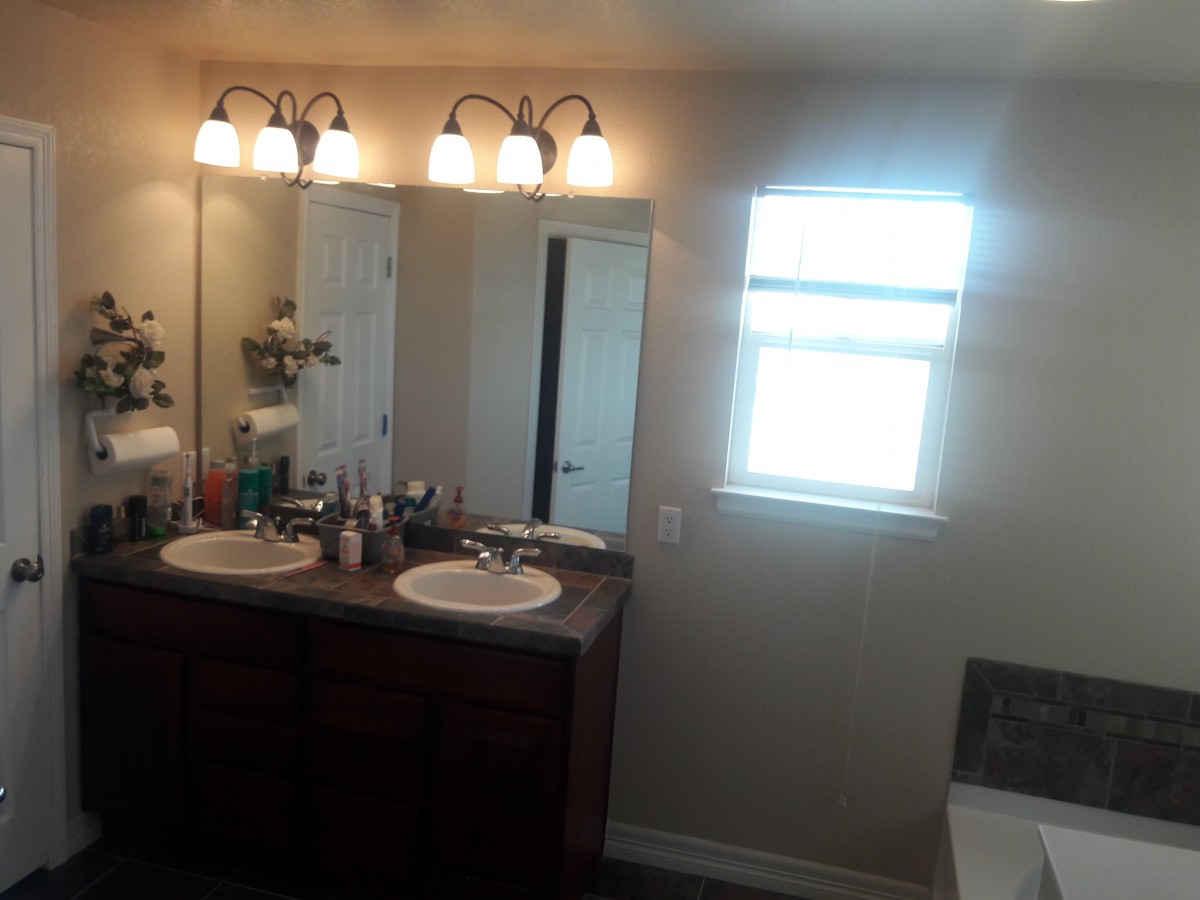 A well-lit bathroom with double sinks and a large mirror.