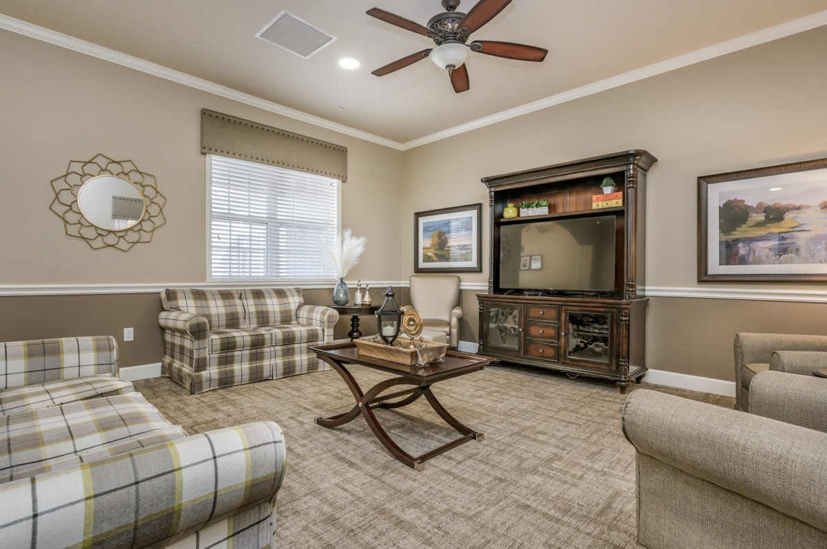 A cozy living room with plaid sofas, a wooden coffee table, and an entertainment cabinet.