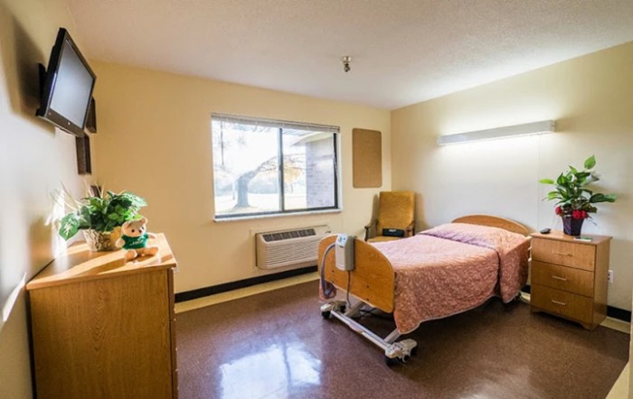 A simple hospital room with a single bed and window.