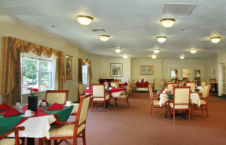 A spacious dining room with neatly arranged tables and chairs, featuring elegant decor and warm lighting.