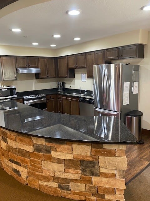 A modern kitchen with granite countertops and stainless steel appliances.