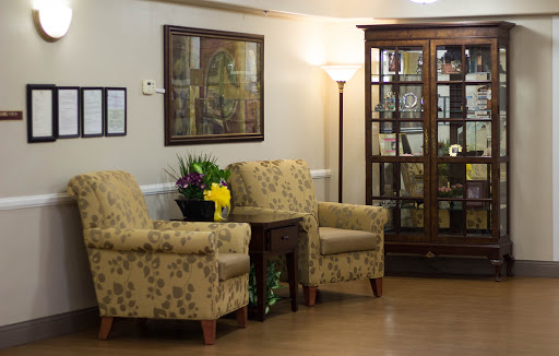 A cozy and inviting seating area featuring stylish floral-patterned chairs and a display cabinet.