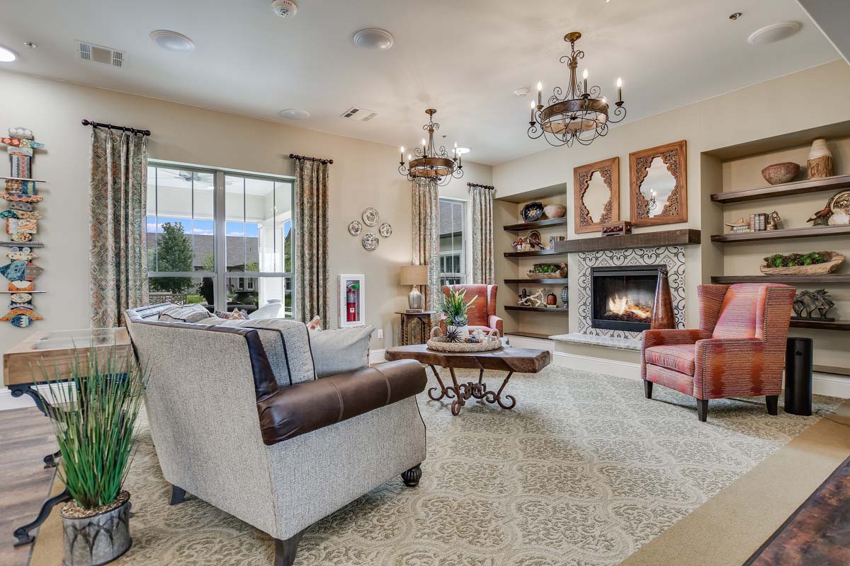 A cozy living room with elegant furnishings, a fireplace, and large windows.