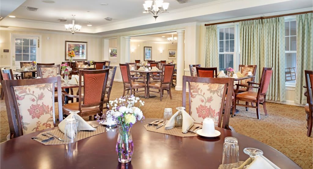An elegantly furnished dining room with neatly arranged tables and chairs, ready for guests.