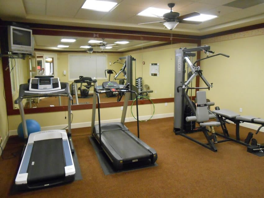 Indoor fitness room with exercise equipment including treadmills and a weight machine.