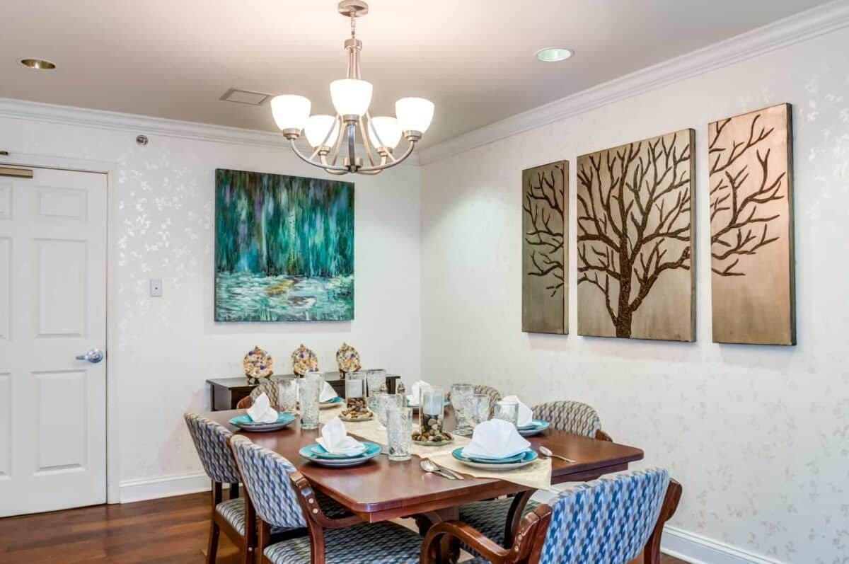 A beautifully decorated dining room with elegant artwork and a well-set table.