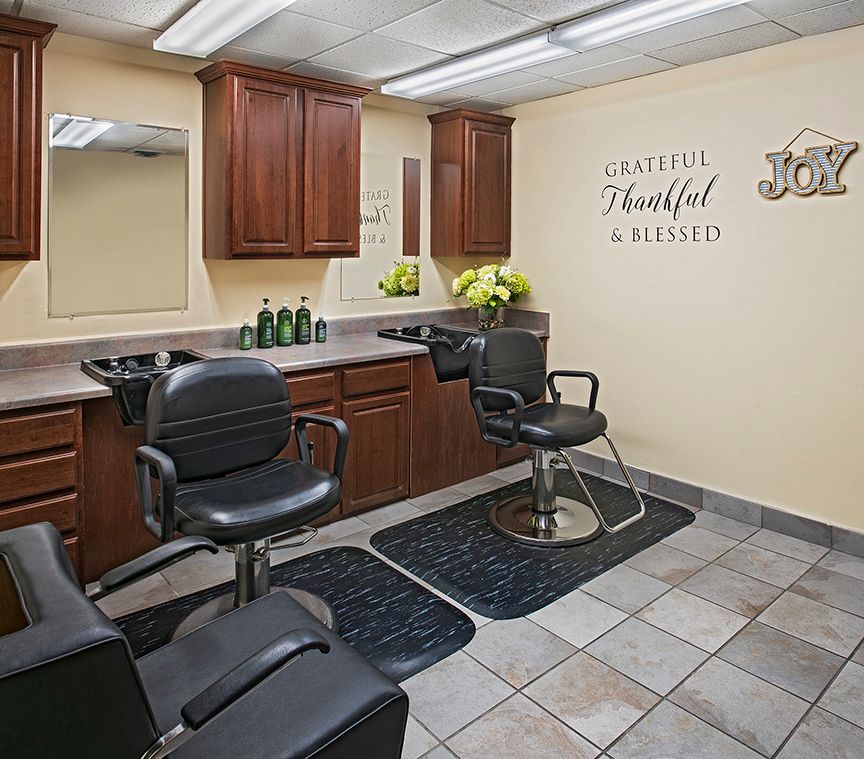 Modern hair salon interior with styling chairs, mirrors, and cabinets.