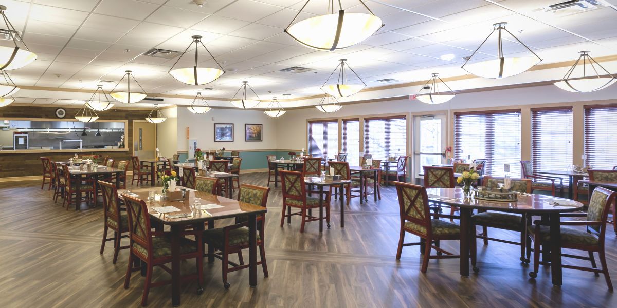 A spacious and well-lit dining area with neatly arranged tables and chairs.