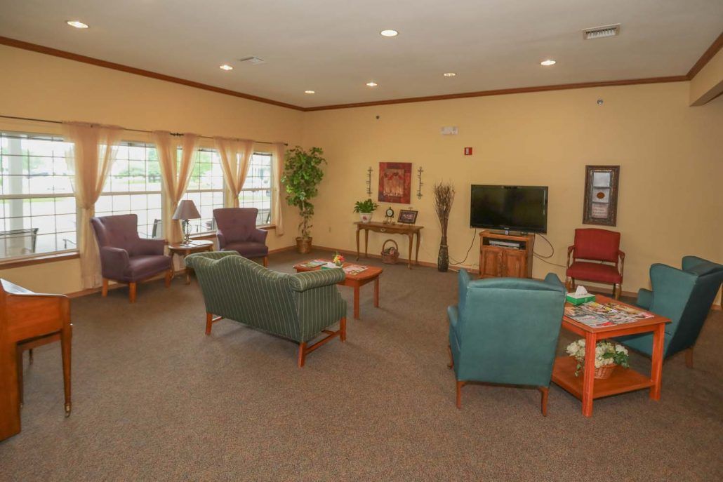 A cozy living room with sofas, chairs, a television, and decorative elements.