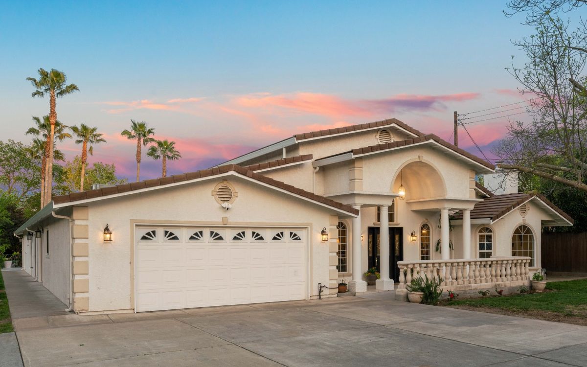 A beautiful two-story house with a sunset backdrop.