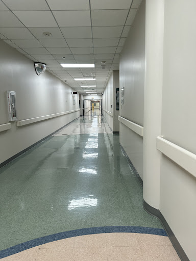 A long, well-lit corridor in a hospital showcasing a clean and orderly environment.