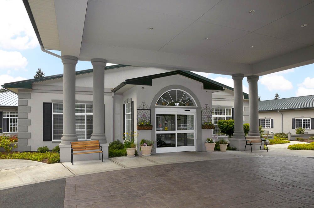 A symmetrical building entrance featuring large columns and a covered walkway.