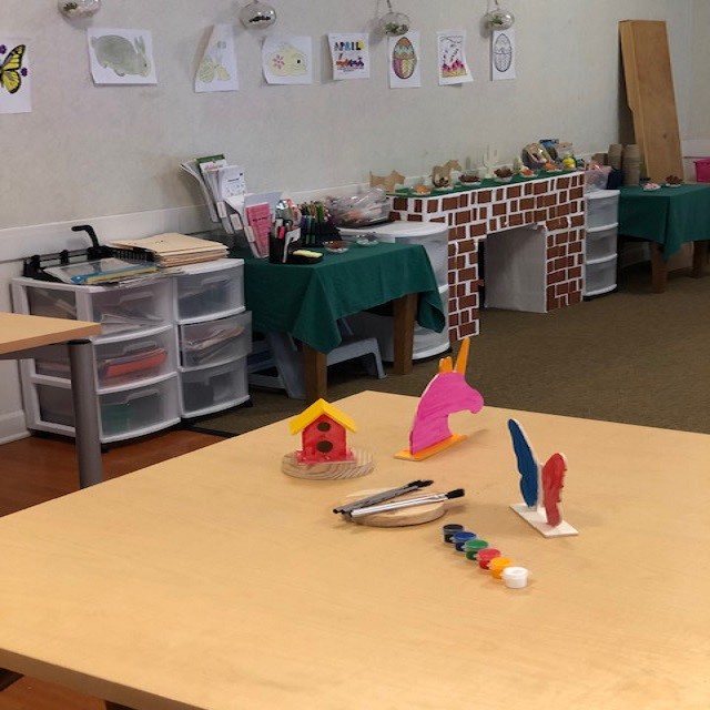 A classroom art area with tables and various craft supplies.
