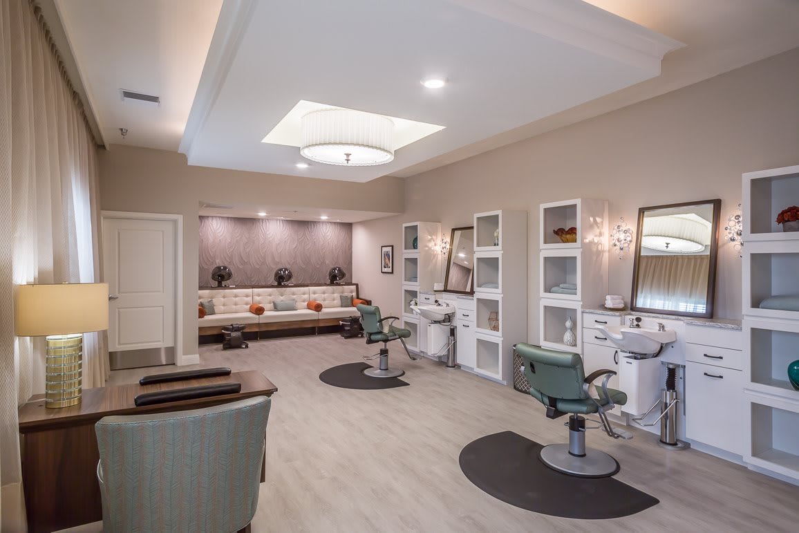 A modern salon interior with styling chairs and a cozy waiting area.