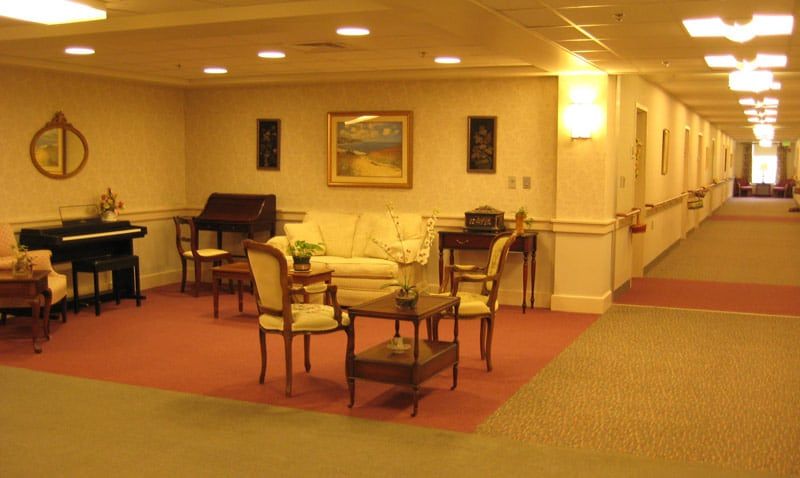A cozy lounge area with traditional furniture and artwork on the walls.