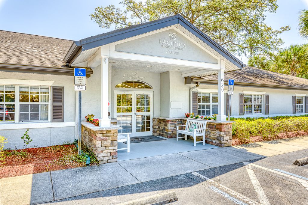 A welcoming entrance of a single-story building with seating and accessible parking.