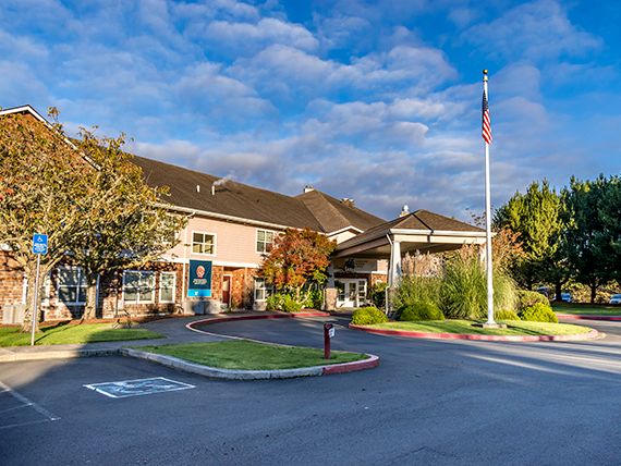A scenic view of a hotel exterior with a clear sky and lush greenery.