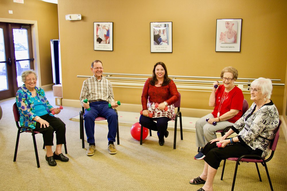 A group of seniors participating in an indoor exercise session.