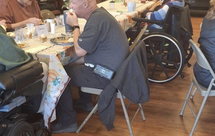 Older adults enjoy a meal together at a community dining setting.